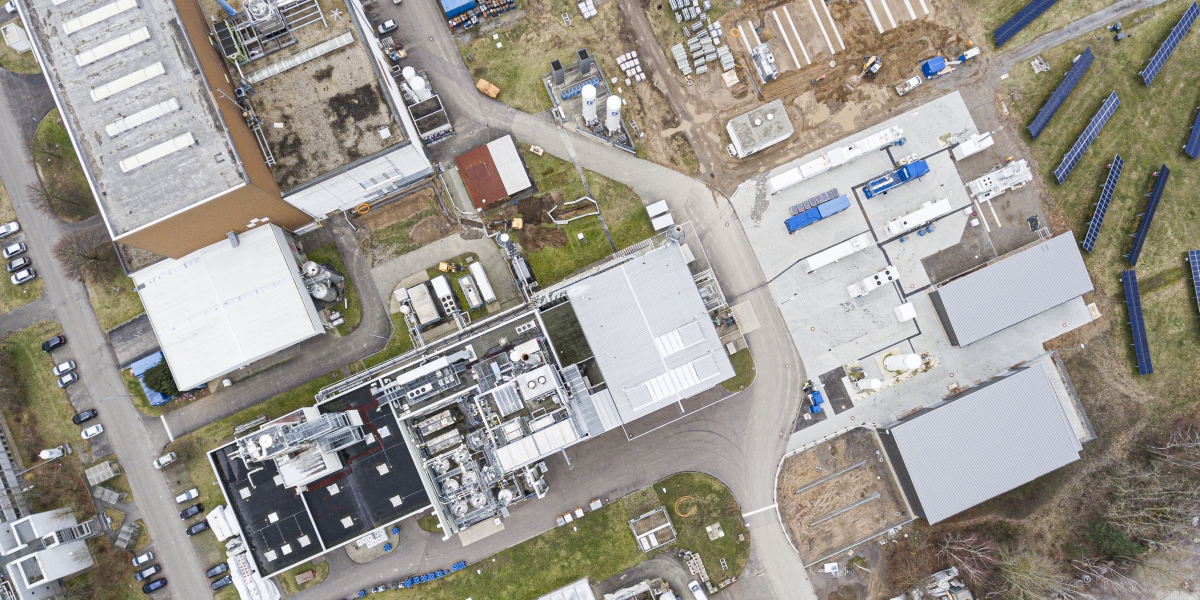 The aerial view of the KIT Energy Lab shows the various buildings and containers belonging to the real-world lab as well as the solar park on the right edge of the screen.